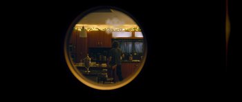 A man standing in a kitchen looking in a mirror