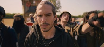 Movie still from “A Place to Fight For” (2023), directed by Romain Cogitore – A person wearing a hat; Close Up shot, Over the shoulder angle