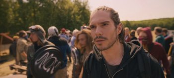 Movie still from “A Place to Fight For” (2023), directed by Romain Cogitore – A person with a beard; Close Up shot, Over the shoulder angle