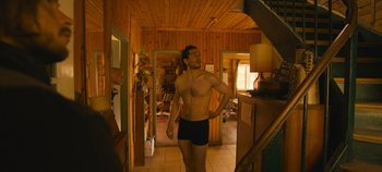 Movie still from “A Place to Fight For” (2023), directed by Romain Cogitore – A man in black trunks standing in a room; Medium shot, Low angle