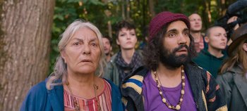 Movie still from “A Place to Fight For” (2023), directed by Romain Cogitore – A group of people standing next to each other in the woods; Close Up shot, Low angle