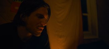 Movie still from “A Place to Fight For” (2023), directed by Romain Cogitore – A person with long dark hair; Close Up shot, High angle