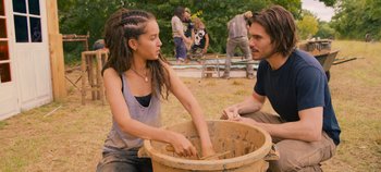 Movie still from “A Place to Fight For” (2023), directed by Romain Cogitore – A man and a woman are playing with a bucket; Medium shot, Over the shoulder angle