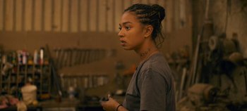 Movie still from “A Place to Fight For” (2023), directed by Romain Cogitore – A young woman holding a remote control in her hand; Close Up shot, Over the shoulder angle