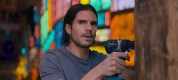 Movie still from “A Place to Fight For” (2023), directed by Romain Cogitore – A person holding a drill; Close Up shot, Low angle
