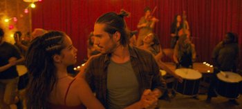 Movie still from “A Place to Fight For” (2023), directed by Romain Cogitore – A man with a bun is dancing with a woman; Close Up shot, Over the shoulder angle