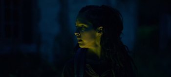 Movie still from “A Place to Fight For” (2023), directed by Romain Cogitore – A woman with dreads is looking into the distance; Close Up shot, Low angle