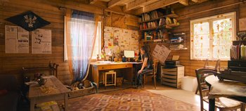 Movie still from “A Place to Fight For” (2023), directed by Romain Cogitore – A woman sitting at a desk in front of a computer; Wide shot, High angle