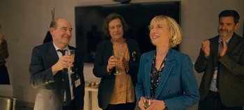 Movie still from “A Place to Fight For” (2023), directed by Romain Cogitore – A group of people standing next to each other holding wine glasses; Medium shot, Over the shoulder angle