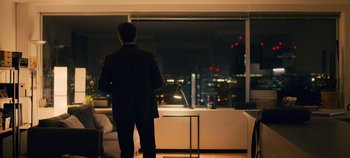 Movie still from “A Place to Fight For” (2023), directed by Romain Cogitore – A man standing in front of a window at night; Wide shot, Over the shoulder angle