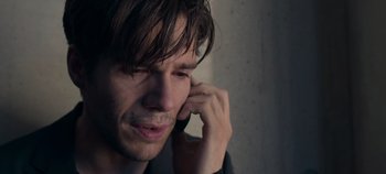 Movie still from “A Place to Fight For” (2023), directed by Romain Cogitore – A person talking on a cell phone; Close Up shot, Over the shoulder angle