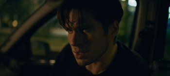 Movie still from “A Place to Fight For” (2023), directed by Romain Cogitore – A person wearing a black shirt; Close Up shot, Over the shoulder angle