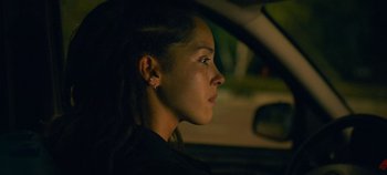 Movie still from “A Place to Fight For” (2023), directed by Romain Cogitore – A woman sitting in the driver's seat of a car at night; Close Up shot, Over the shoulder angle