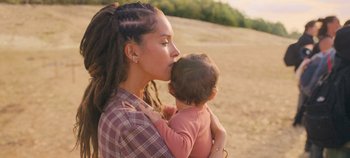 Movie still from “A Place to Fight For” (2023), directed by Romain Cogitore – A woman holding a baby in her arms and kissing her face; Close Up shot, Over the shoulder angle