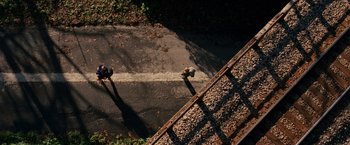 Movie still from “A Quiet Place” (2018), directed by John Krasinski – An overhead view of a person walking down the street; Extreme Wide shot, Overhead angle