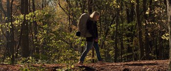 Movie still from “A Quiet Place” (2018), directed by John Krasinski – A woman walking through the woods with a backpack; Wide shot, Low angle