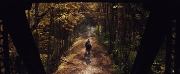 Movie still from “A Quiet Place” (2018), directed by John Krasinski – Two people riding a motorcycle down a dirt road; Extreme Wide shot, High angle