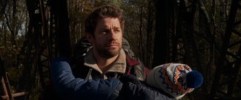 Movie still from “A Quiet Place” (2018), directed by John Krasinski – A person wearing a jacket near a forest; Medium shot, Over the shoulder angle