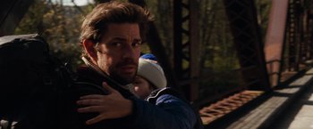 Movie still from “A Quiet Place” (2018), directed by John Krasinski – A person holding a child; Medium shot, Over the shoulder angle