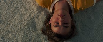 Movie still from “A Quiet Place” (2018), directed by John Krasinski – A person laying on the ground with their head down; Close Up shot, Overhead angle
