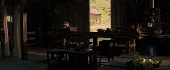 Movie still from “A Quiet Place” (2018), directed by John Krasinski – A room filled with wooden tables and chairs and a window; Wide shot, High angle