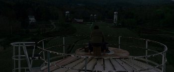 Movie still from “A Quiet Place” (2018), directed by John Krasinski – A man sitting on top of a metal structure; Extreme Wide shot, High angle