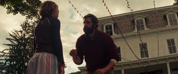 Movie still from “A Quiet Place” (2018), directed by John Krasinski – A man and a woman standing next to each other outside; Medium shot, Low angle