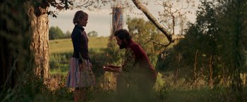 Movie still from “A Quiet Place” (2018), directed by John Krasinski – A man kneeling down next to a woman in a field; Wide shot, Over the shoulder angle