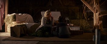 Movie still from “A Quiet Place” (2018), directed by John Krasinski – Two women sitting on the ground in front of a white board; Wide shot, Over the shoulder angle