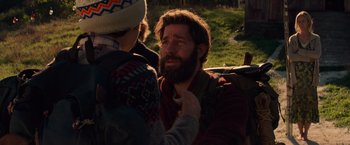 Movie still from “A Quiet Place” (2018), directed by John Krasinski – A man with long hair and a goatee has his beard pulled back by another man; Close Up shot, Over the shoulder angle