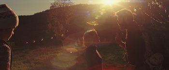 Movie still from “A Quiet Place” (2018), directed by John Krasinski – A woman standing next to a tree in a field; Wide shot, Over the shoulder angle