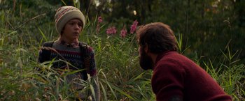 Movie still from “A Quiet Place” (2018), directed by John Krasinski – A man and a boy in a field of flowers; Medium shot, Over the shoulder angle