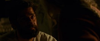 Movie still from “A Quiet Place” (2018), directed by John Krasinski – A man with a beard is looking at the camera; Close Up shot, Over the shoulder angle
