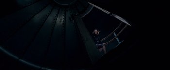 Movie still from “A Quiet Place” (2018), directed by John Krasinski – A woman standing inside of an airplane looking out of the window; Wide shot, Overhead angle