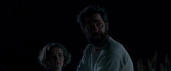 Movie still from “A Quiet Place” (2018), directed by John Krasinski – A man and a woman standing next to each other in the dark; Medium shot, Over the shoulder angle