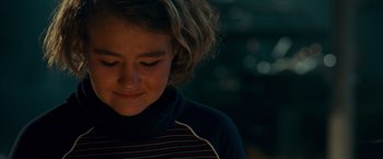 Movie still from “A Quiet Place” (2018), directed by John Krasinski – A young woman with short curly hair wearing a striped shirt; Close Up shot, Over the shoulder angle