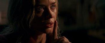 Movie still from “A Quiet Place” (2018), directed by John Krasinski – A person with a finger up to her mouth; Close Up shot, Over the shoulder angle