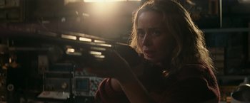 Movie still from “A Quiet Place” (2018), directed by John Krasinski – A woman holding a cell phone while standing in front of a plane; Close Up shot, Over the shoulder angle