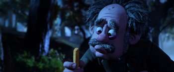 Movie still from “A Shaun the Sheep Movie: Farmageddon” (2019), directed by Will Becher – A person holding a piece of food; Close Up shot, Over the shoulder angle