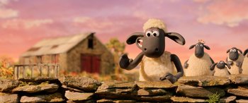 Movie still from “A Shaun the Sheep Movie: Farmageddon” (2019), directed by Will Becher – A toy sheep sitting on top of a stone wall; Medium shot, Low angle