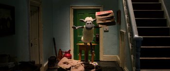 Movie still from “A Shaun the Sheep Movie: Farmageddon” (2019), directed by Will Becher – A stuffed sheep standing on top of a wooden stool; Wide shot, High angle