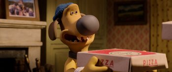 Movie still from “A Shaun the Sheep Movie: Farmageddon” (2019), directed by Will Becher – A toy dog holding a box of pizza; Close Up shot, Over the shoulder angle