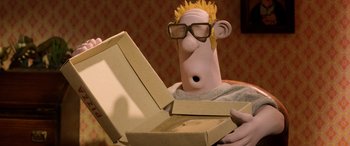 Movie still from “A Shaun the Sheep Movie: Farmageddon” (2019), directed by Will Becher – A person holding open a box with a cartoon character on it; Close Up shot, High angle