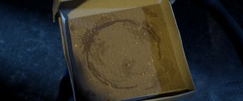 Movie still from “A Shaun the Sheep Movie: Farmageddon” (2019), directed by Will Becher – A cardboard box that has a circle drawn on it; Extreme Close Up shot, Overhead angle
