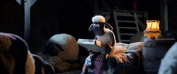 Movie still from “A Shaun the Sheep Movie: Farmageddon” (2019), directed by Will Becher – A stuffed sheep sitting on top of a blanket; Wide shot, High angle