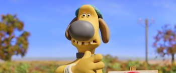 Movie still from “A Shaun the Sheep Movie: Farmageddon” (2019), directed by Will Becher – A cartoon dog's face with a blue sky in the background; Close Up shot, Over the shoulder angle