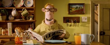 Movie still from “A Shaun the Sheep Movie: Farmageddon” (2019), directed by Will Becher – A man in a yellow sweater is reading a magazine; Medium shot, Low angle