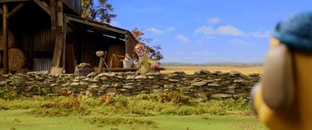 Movie still from “A Shaun the Sheep Movie: Farmageddon” (2019), directed by Will Becher – An animated woman sitting on a stone wall with a pot; Wide shot, Low angle