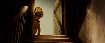 Movie still from “A Shaun the Sheep Movie: Farmageddon” (2019), directed by Will Becher – A large stuffed dog standing in front of an open door; Medium shot, Low angle