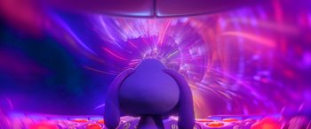 Movie still from “A Shaun the Sheep Movie: Farmageddon” (2019), directed by Will Becher – A person's head in front of a colorful background; Medium shot, High angle